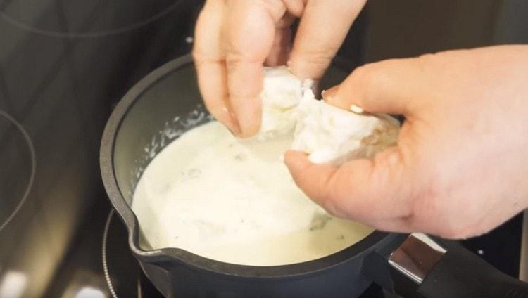 Agregue el queso roto en trozos en la salsa.