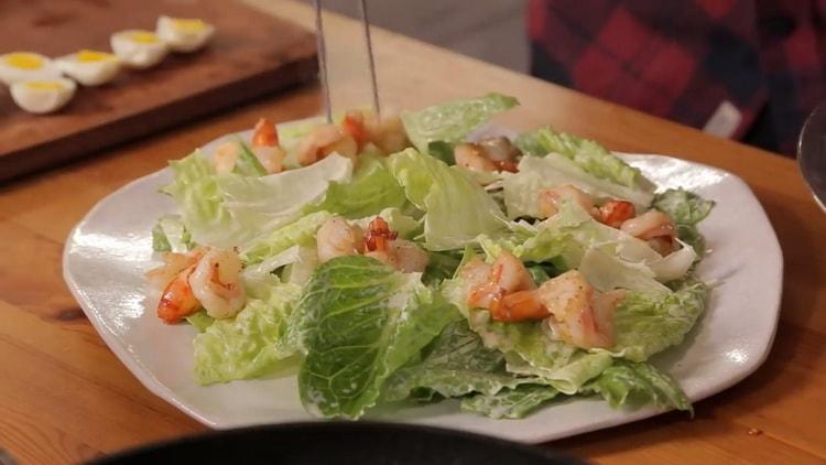Mettez les crevettes sur la salade pour faire la salade