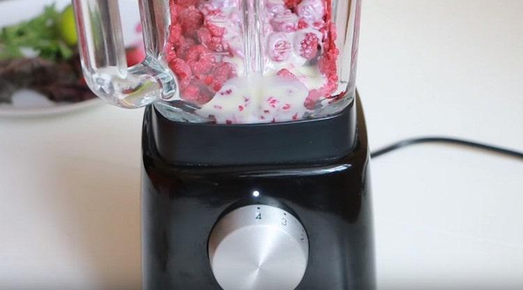 Batir las frambuesas con leche condensada con una licuadora.