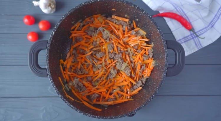 Agregue zanahorias a la cebolla con carne.