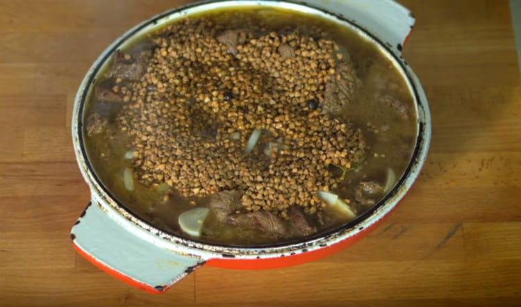 Add buckwheat and water, return the dish to the oven.