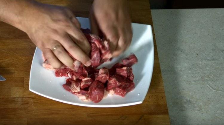Cortar la carne en trozos, sazonar con sal y pimienta.