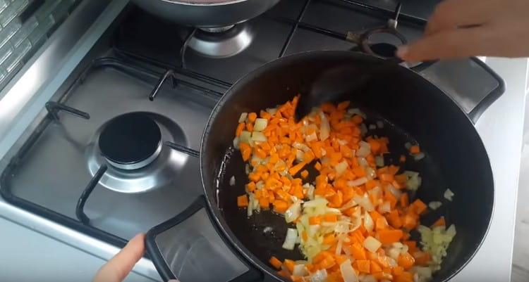 Ajoutez des carottes à l'oignon et faites frire les légumes.