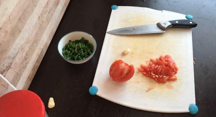 Cut tomato into slices, chop greens and garlic.