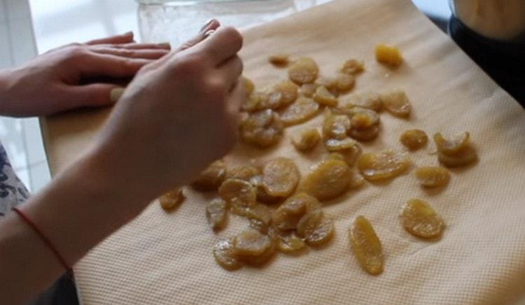 Lay out pieces of ginger on parchment to dry, sprinkling them with sugar.