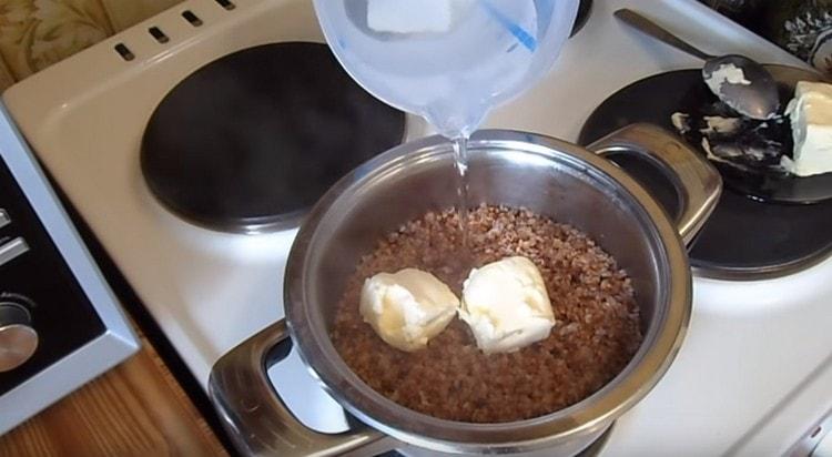 En el trigo sarraceno casi terminado, agregue mantequilla y un poco de agua.