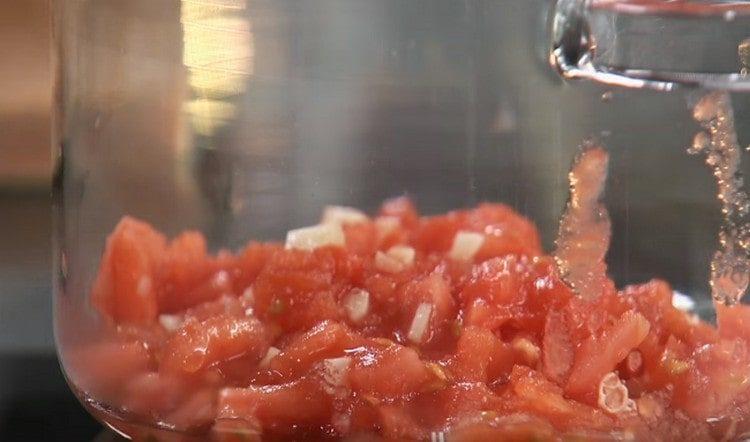 Finely chop the tomatoes, mix them with garlic and put in a saucepan.