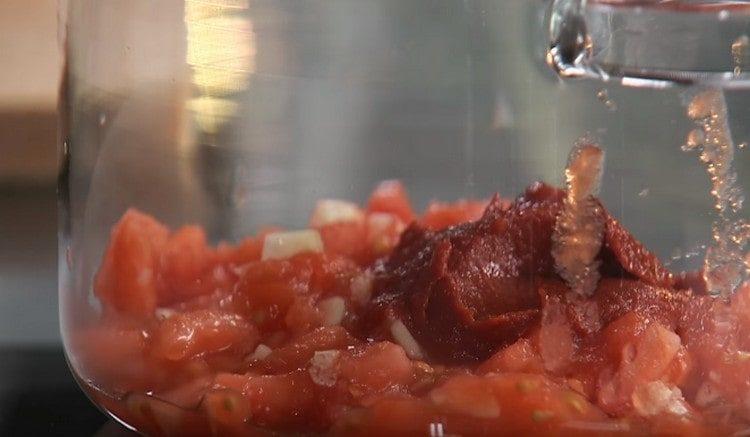 Pridajte paradajkovú pastu na paradajky s cesnakom.