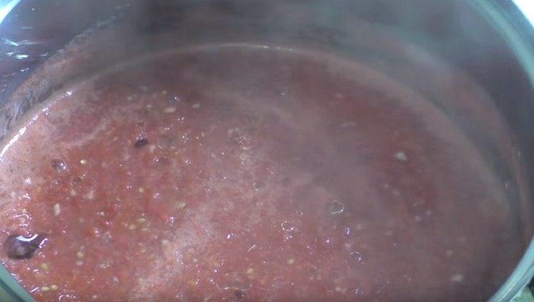 pon la masa de tomate en la estufa para cocinar.