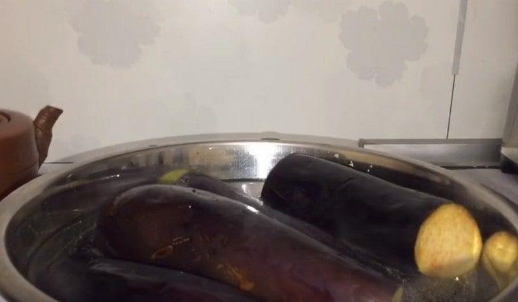 Después de cortar las colas de la berenjena, colóquelas en una olla con agua hirviendo y cocine durante 7 minutos.
