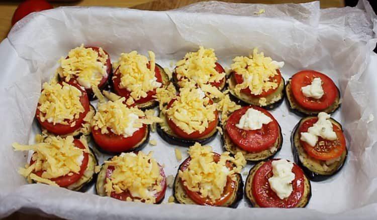 Sur les tomates, étendre le fromage à la crème, saupoudrer de fromage râpé.