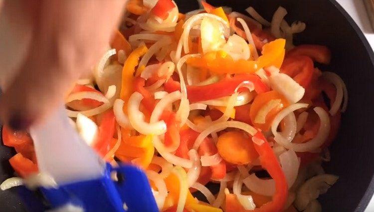 we also cut onions, sweet peppers, add to the carrots in a pan.