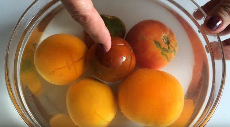 Vierte los tomates con agua hirviendo.