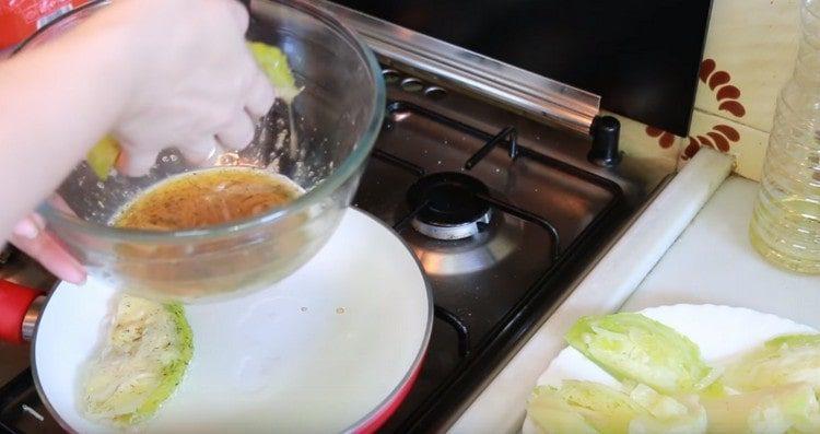 Dip each slice of cabbage in an egg and spread on a well-heated pan with vegetable oil.