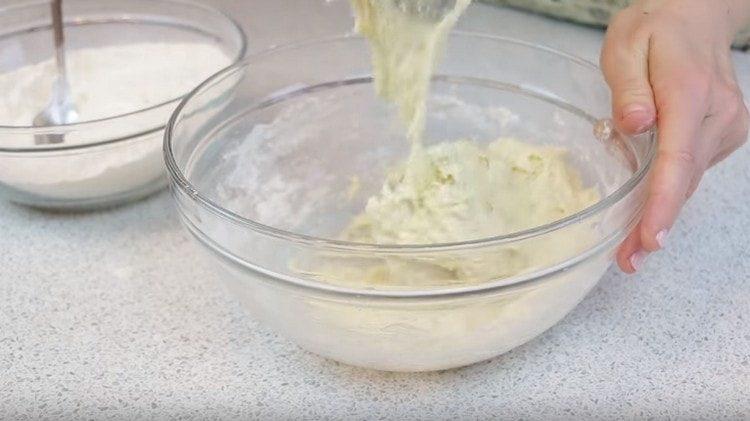 Ajoutez une autre partie de la farine et mélangez la pâte.