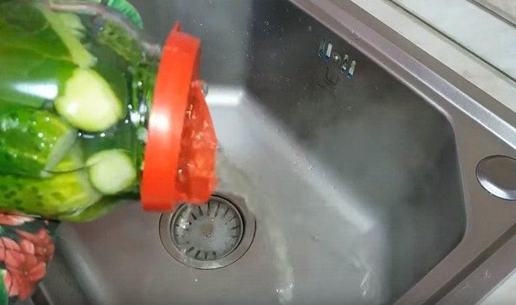 We completely drain the water from the cans of cucumbers.