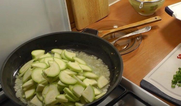 We spread the sliced ​​zucchini into the pan.