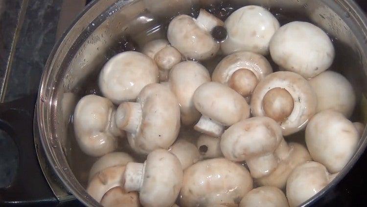 In a boiling marinade, spread the mushrooms.