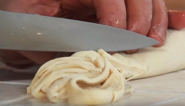 We roll the dough into a roll and cut the noodles.