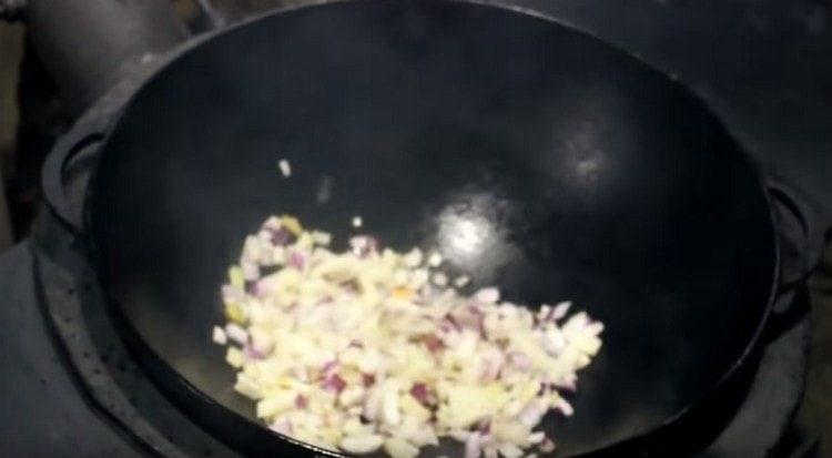 Fry chopped onions in a cauldron