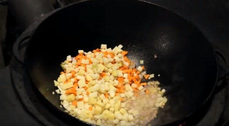 Agregue zanahorias y papas finamente picadas a la cebolla.