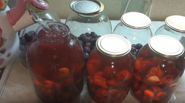 Remplissez les boîtes de conserve de prunes avec de l'eau bouillante.