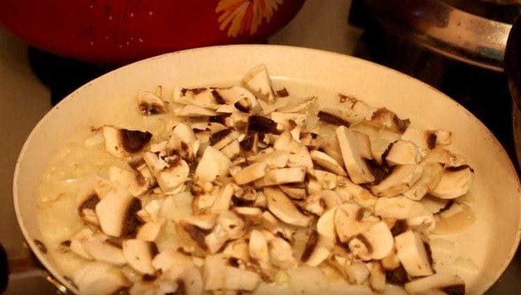 Bak de ui met champignons in een pan.