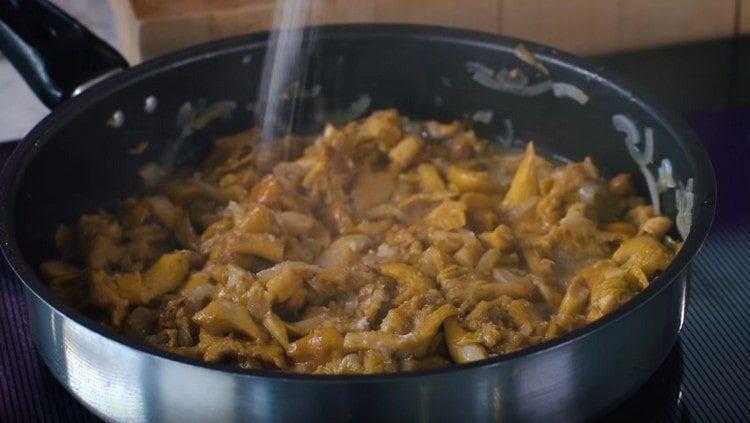 Mushrooms with onions are salted and removed from the stove.