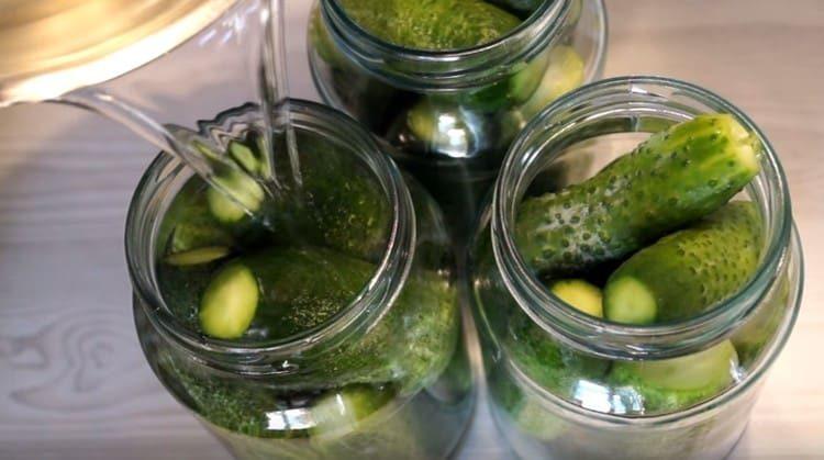 Pour cucumbers in jars with marinade.