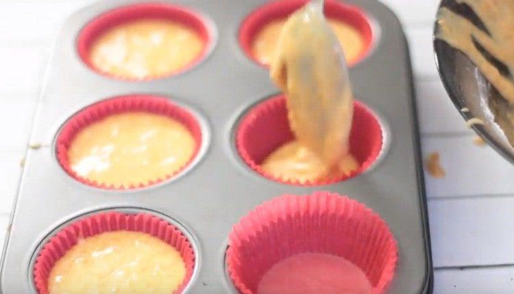 Ibuhos ang masa sa muffin tins.