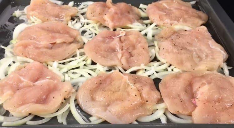On the other baking sheet, put the onion and pieces of chicken.