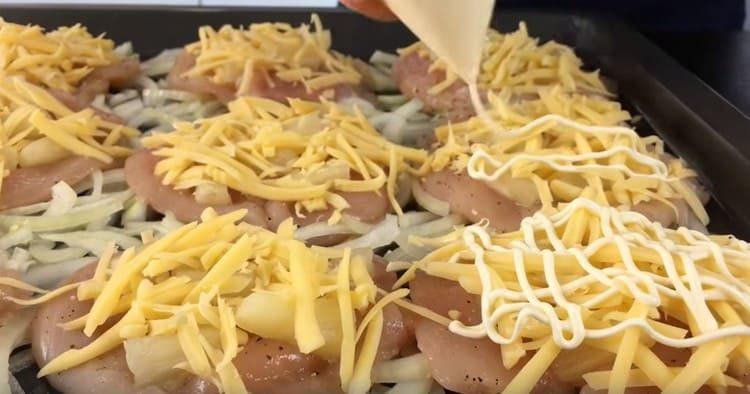 En la parte superior del filete de pollo, también colocamos piñas, queso, mayonesa.