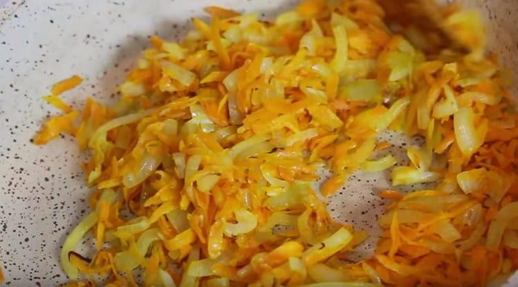 Faites frire les oignons avec les carottes dans l'huile végétale jusqu'à ce qu'ils soient tendres.