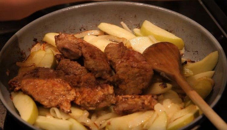 Des morceaux de foie frits passent à l'oignon avec des pommes.