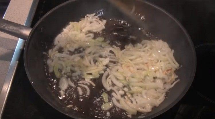 Fry the onion sliced ​​in half rings in a pan.