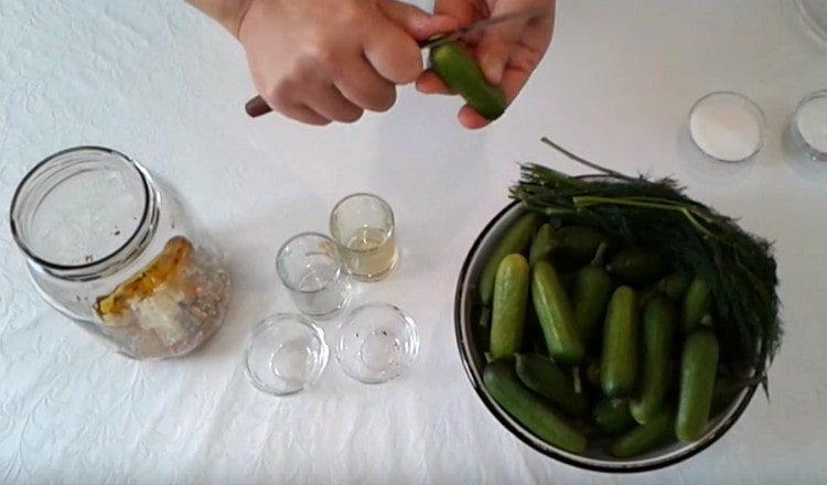 Cut the ends of the cucumbers and put them in a jar.