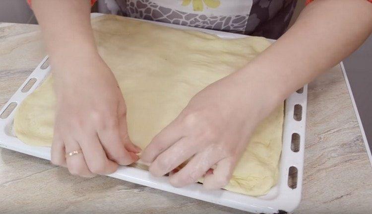 roll out the second piece of dough, cover them with the filling and pinch the edges.