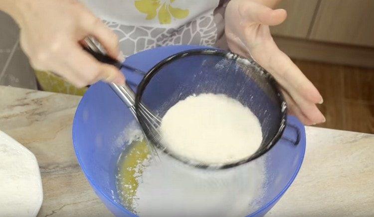 Verser la farine en petites portions et pétrir la pâte.