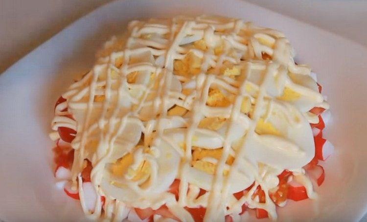 Ponemos los trozos de huevos sobre los tomates, los engrasamos con mayonesa.
