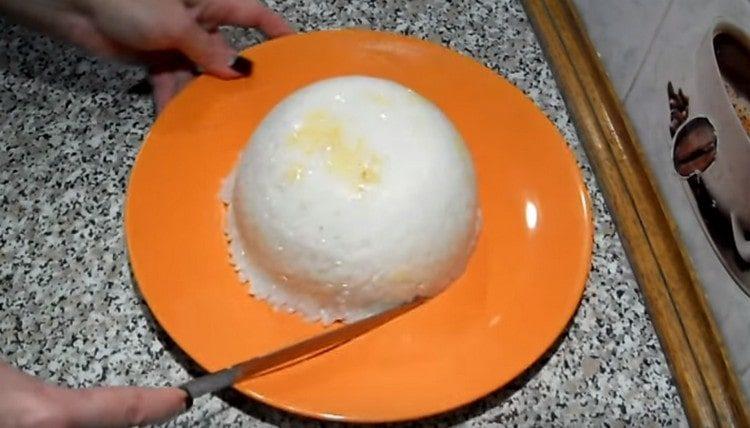 Cubra la carne con el arroz restante y voltee el tazón al plato para servir.