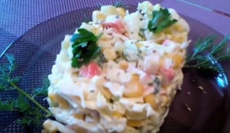Salad with cabbage, crab sticks and corn is ready.