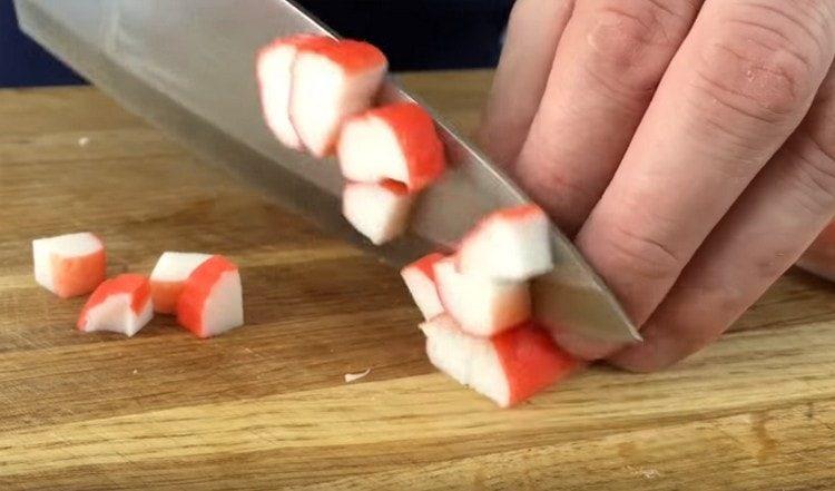 Cut into pieces crab sticks.