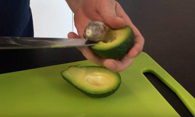 Snijd de avocado doormidden en verwijder de steen.