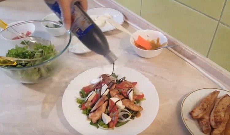 Nous décorons la salade avec des tomates séchées au soleil avec des tranches de mozzarella et versons une crème balsamique dessus.