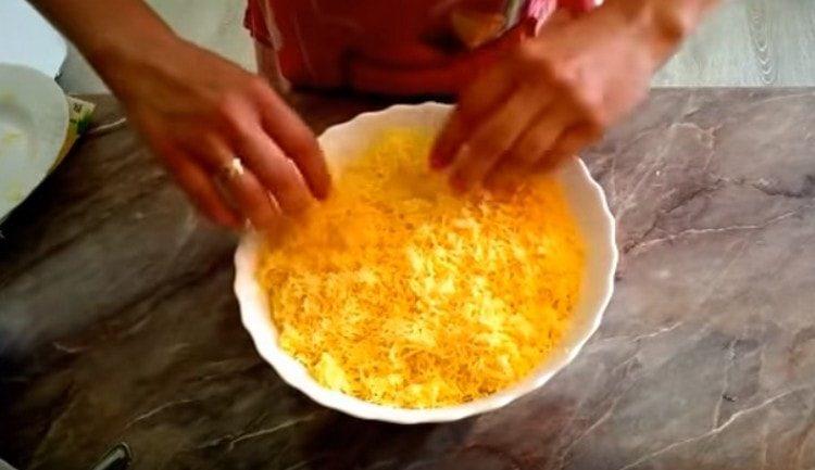 Extender una capa de queso rallado.