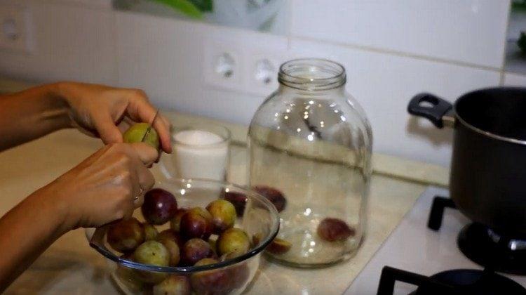 Hugasan ang mga plum, alisin ang mga buto at ilagay ito sa isang garapon.