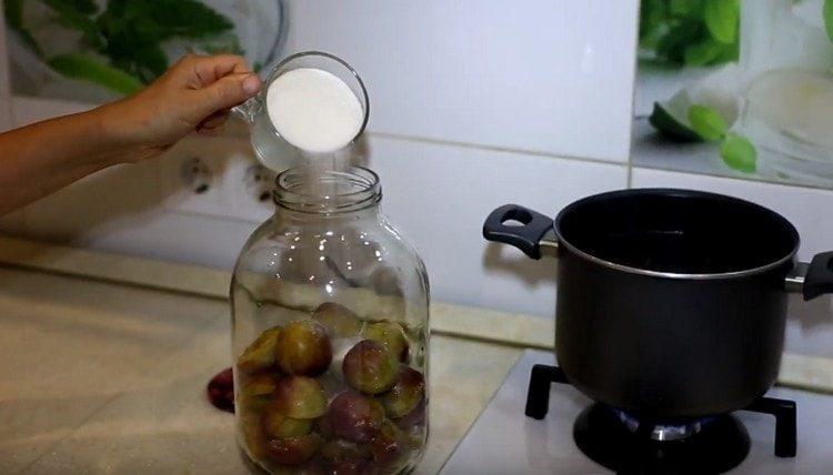 Add sugar to the plums in a jar.