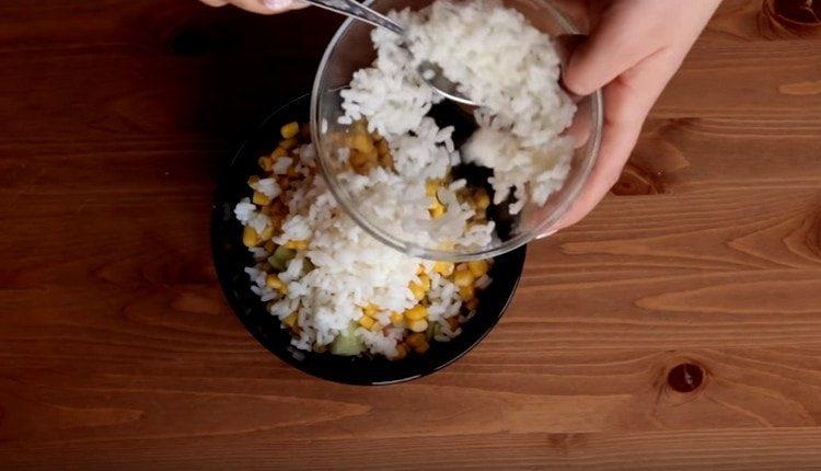 Dodajte kuhanu rižu i kukuruz štapićima krastavaca i rakova.