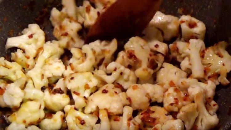 Add pre-boiled cauliflower to the pan in the pan.