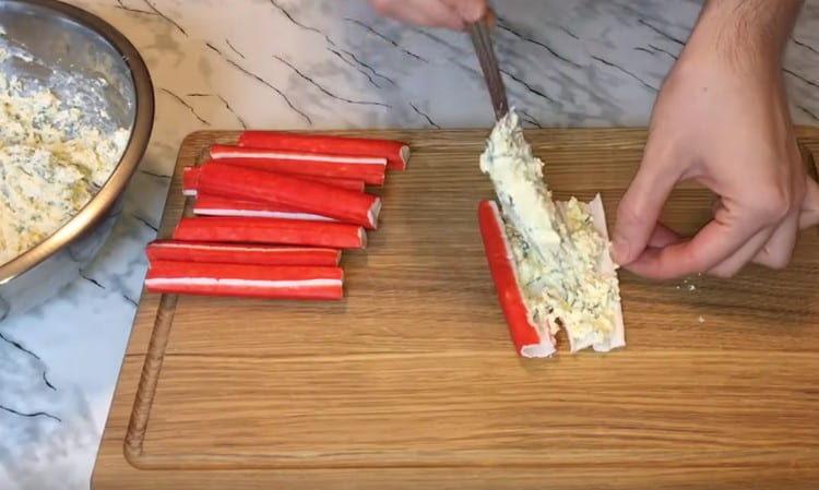 Lubricate the expanded crab stick with the filling.